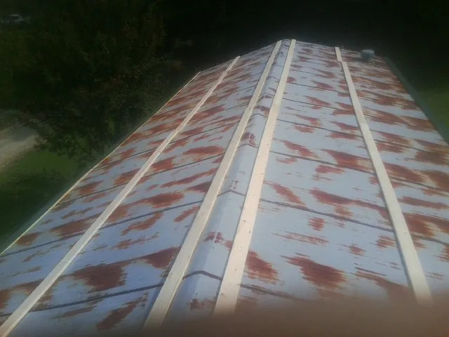 Rusted metal roof panels with new wood purlins before replacement — Storm Damage Roof Repair in Ulen by Roofing Brothers
