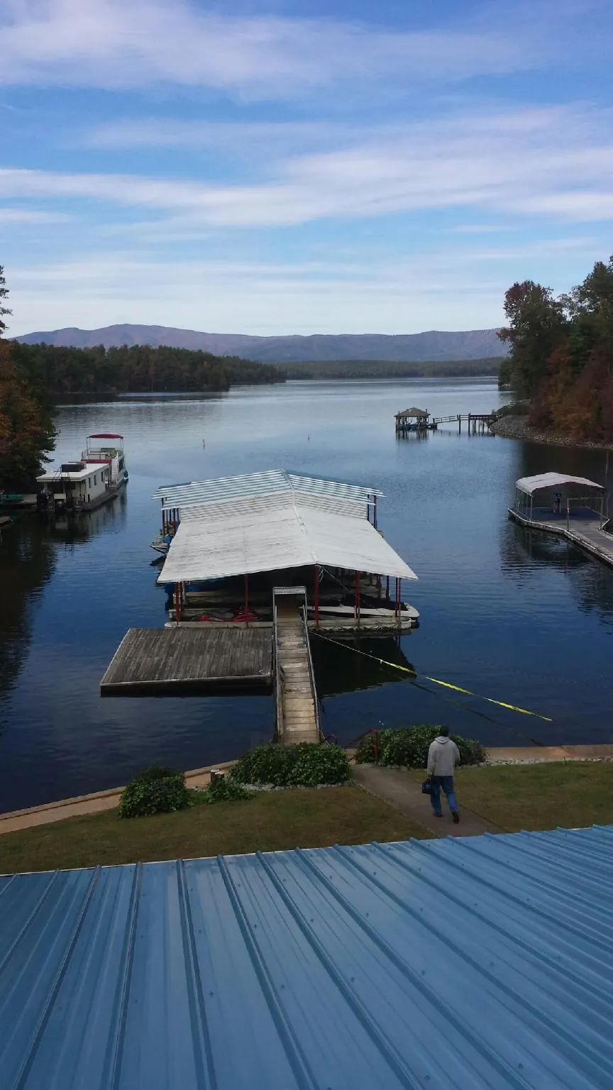 View across a lake from a newly installed blue metal roof in Ulen
