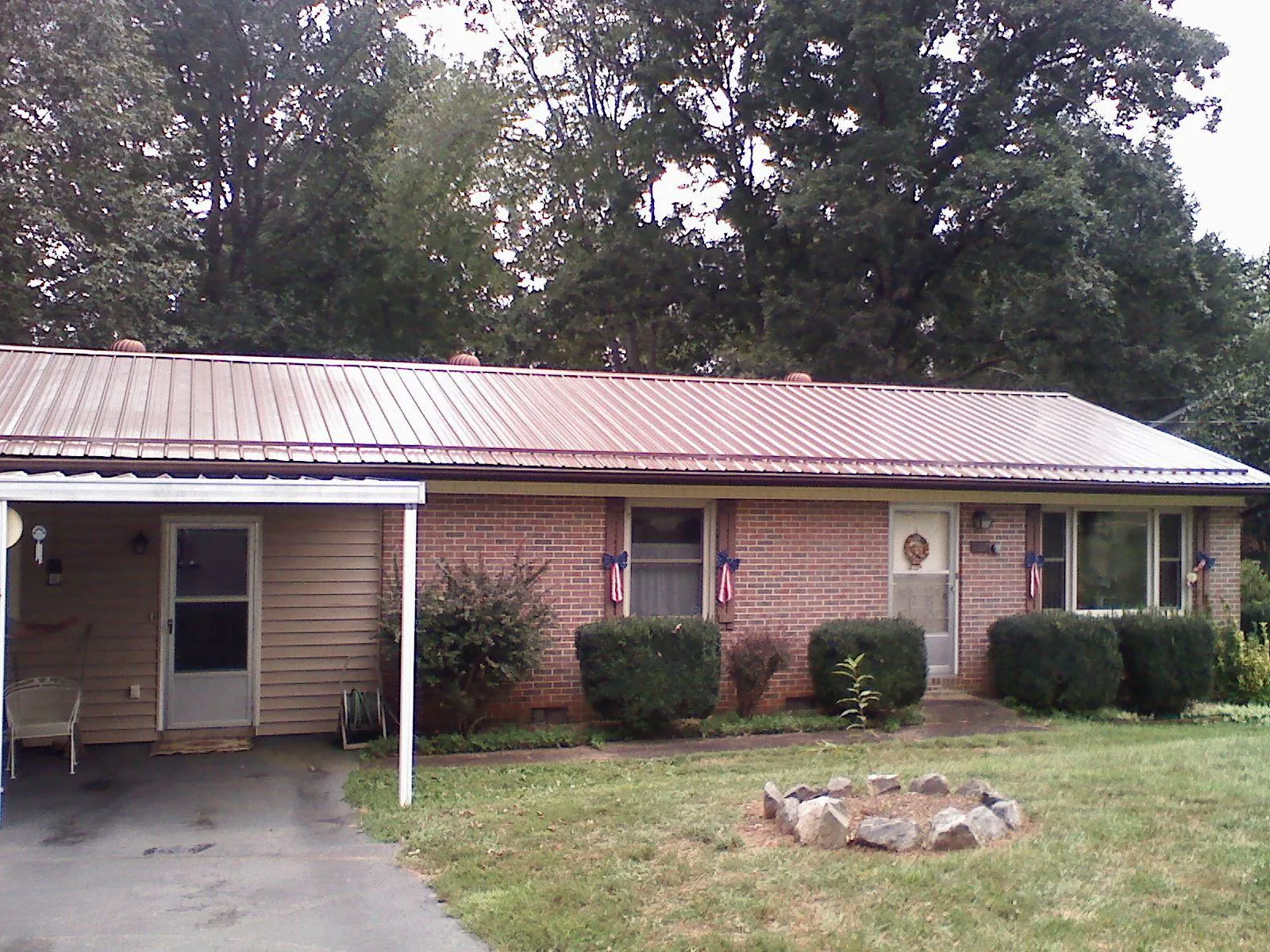 Bronze metal roof and carport on a brick ranch home — Roof Repair work by our crew in Ulen